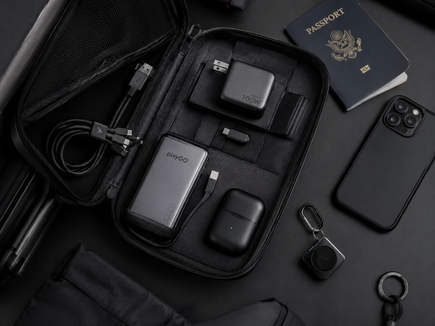 Compact travel charging kit with power bank, universal cable, charger, adapters, earbuds, phone, and passport.