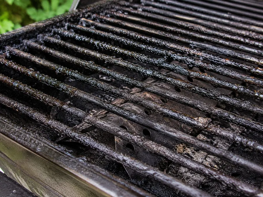 Dirty BBQ grill grates with grease and stuck-on residue before cleaning