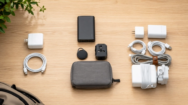Chargers, cables, power bank, tracker, travel adapter, and organizer arranged for portable tech purchase planning